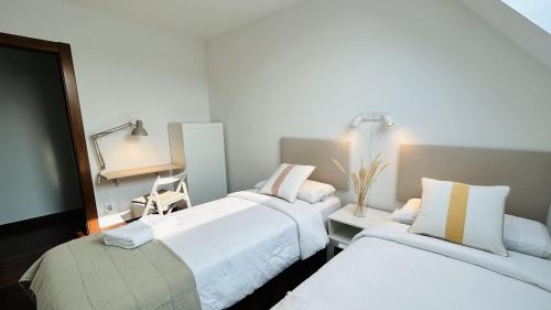聖克魯斯德貝札納的住宿－Atico Duplex con terraza en Santander，酒店客房配有两张床和一张书桌