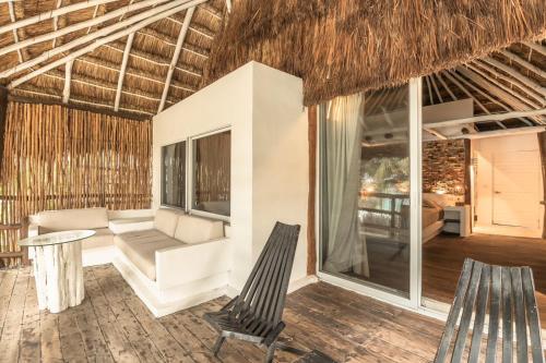 a living room with chairs and a couch and a table at Niken Beachfront Tulum Hotel in Tulum