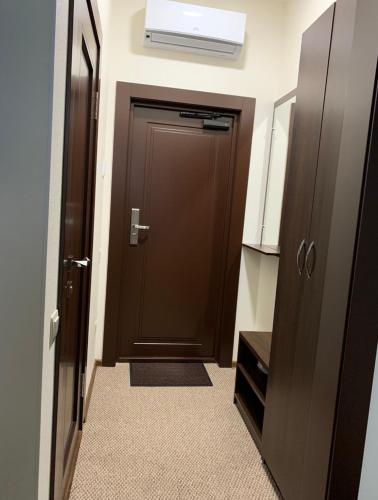 a hallway with a brown door and a room at Петрівський in Kropyvnytskyi