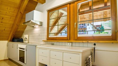 uma cozinha com armários brancos e uma janela em Haus Miriam em Münstertal