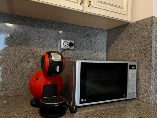um robô está sentado ao lado de um micro-ondas em Апартамент за гости “Диана” em Burgas
