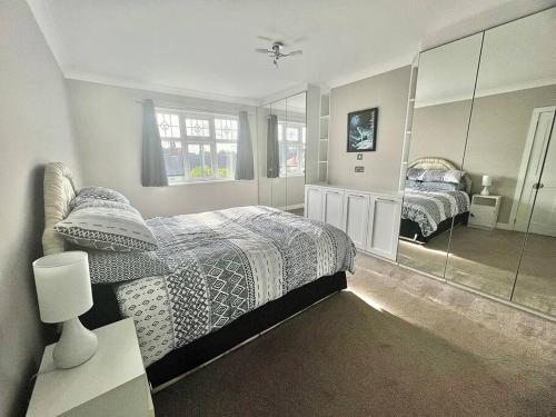 a bedroom with two beds and a large mirror at Cosy Modern Grimsby Home in Great Coates