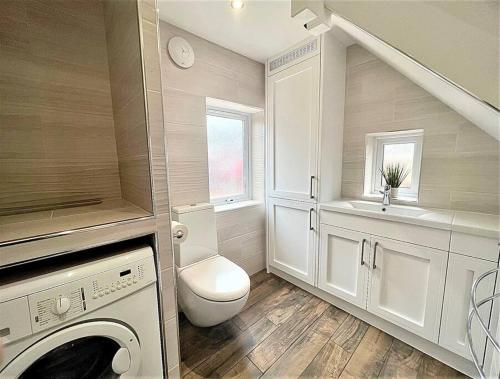 a bathroom with a toilet and a sink at Cosy Modern Grimsby Home in Great Coates