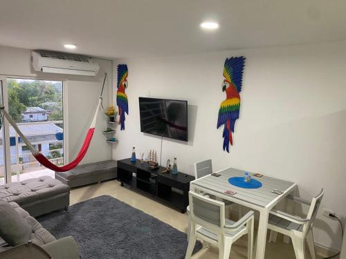 a living room with a table and some colorful birds on the wall at Apartamento amoblado (Coveñas) in Coveñas