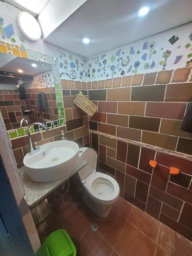 a bathroom with a toilet and a sink at Finca La Aurora in Tibasosa