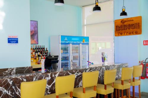 a bar with yellow chairs and a counter at Best Western Dodoma City Hotel in Dodoma