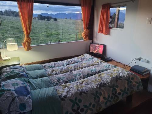 a bedroom with a bed and a large window at Finca La Aurora in Tibasosa