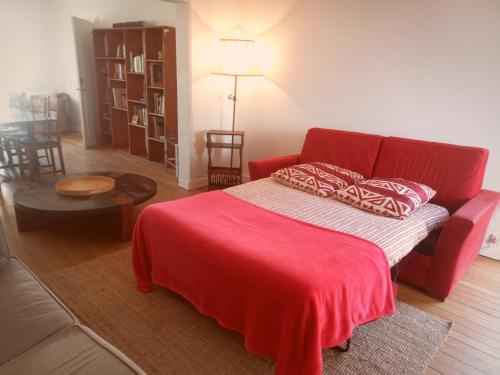 - un salon avec un canapé rouge et une couverture rouge dans l'établissement Maison Des Pas Enchantés, à Saint-Sébastien-sur-Loire