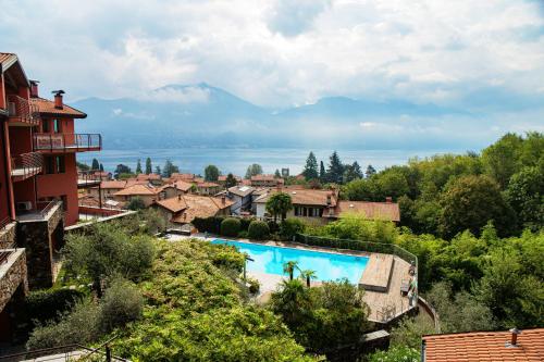 a resort with a swimming pool and mountains in the background at Bella Lì - by MyHomeInComo in Menaggio