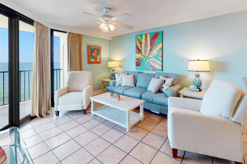 a living room with a blue couch and chairs at Phoenix Vacation Rentals in Orange Beach