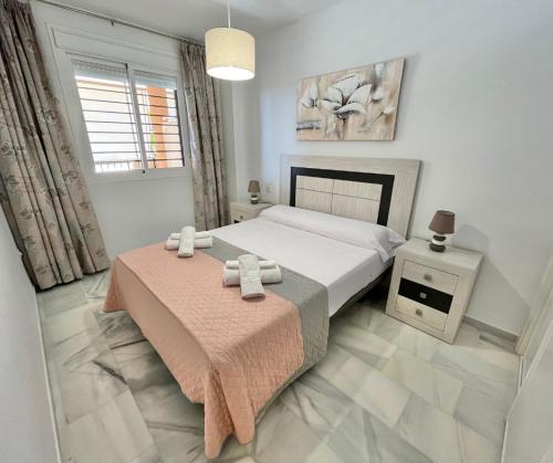 a bedroom with a bed and a table with towels on it at Doña Julia Golf in Casares