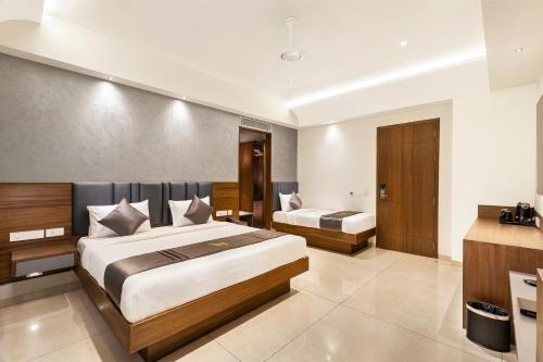 a hotel room with two beds and a bathroom at Narthaki Boutique Hotel in Bengaluru