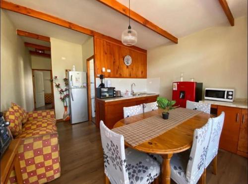 a kitchen and dining room with a table and chairs at Cabaña y Depto Puclaro in Vicuña