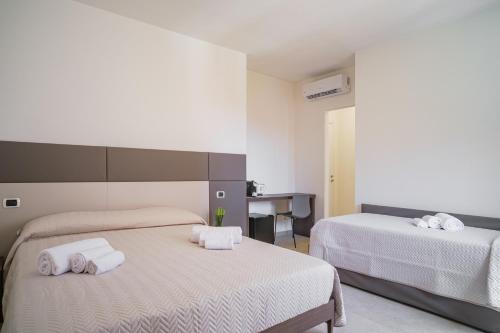 ein Schlafzimmer mit 2 Betten und Handtüchern darauf in der Unterkunft AS 10 HOUSE in Olbia