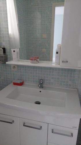 ein Badezimmer mit einem weißen Waschbecken und einem Spiegel in der Unterkunft Villa Machilly in Machilly