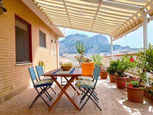 una mesa y sillas en un patio con plantas en Casa di Frank: appartamento a due passi dal mare, en Cefalú