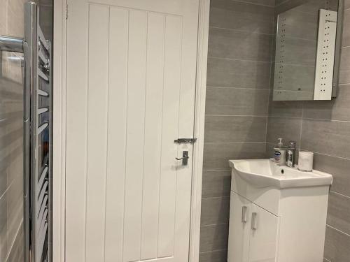 ein Badezimmer mit einem weißen Schrank und einem Waschbecken in der Unterkunft Beautiful Holiday Cottage in Ashbourne
