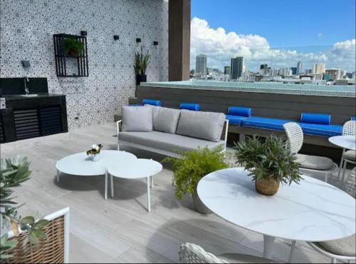 a patio with a couch and tables on a roof at Downtown Santo Domingo Luxury Apartment in Santo Domingo