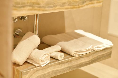 a pile of towels on a shelf in a bathroom at Kompleksi Turistik DEA in Shkodër