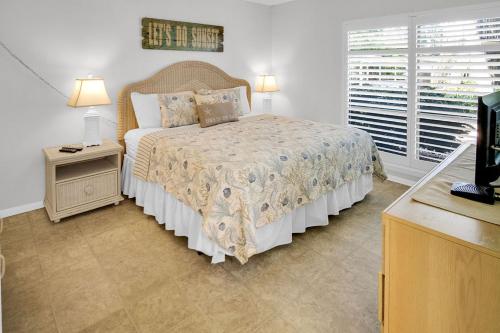 a bedroom with a large bed and a window at Siesta Key Escape Ground Floor Steps to Heated Pool and Free Trolley in Siesta Key