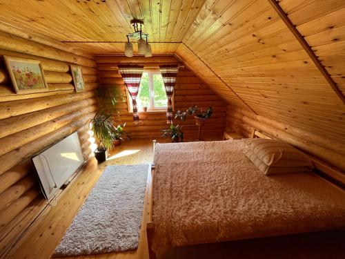 a bedroom with a bed in a wooden cabin at Beautiful house in Pilipets