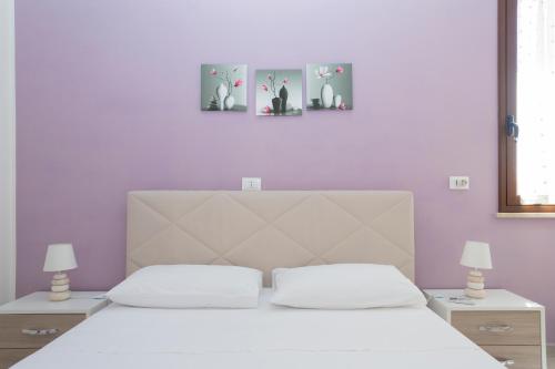 a bedroom with a large white bed with two lamps at La Dimora Di Segesta B&B in Calatafimi