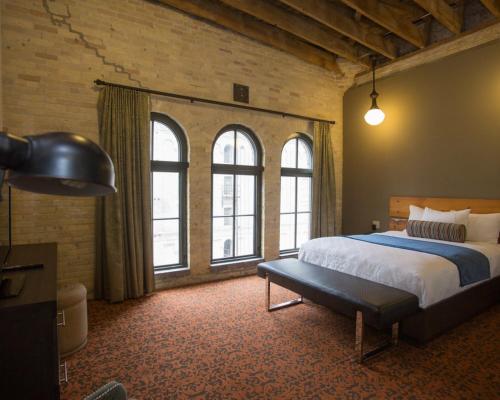 a bedroom with a large bed and windows at Brewhouse Inn and Suites in Milwaukee