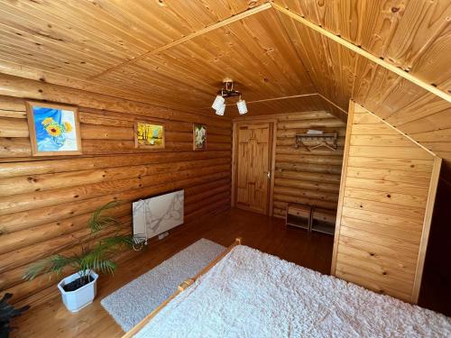 an attic room with wooden walls and a wooden ceiling at Beautiful house in Pilipets