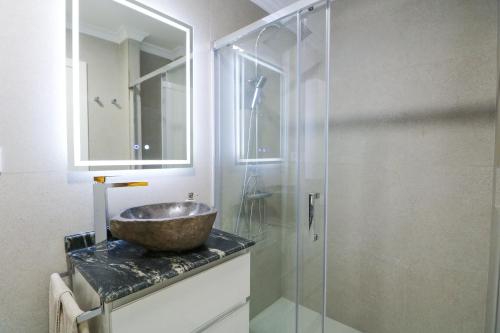 y baño con lavabo y ducha acristalada. en Agaete Sunset Vista with jacuzzi 2-BR Apartment, en Puerto de las Nieves
