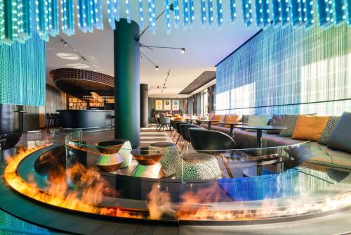 a lobby with a fire pit and tables and chairs at Park Plaza Budapest in Budapest