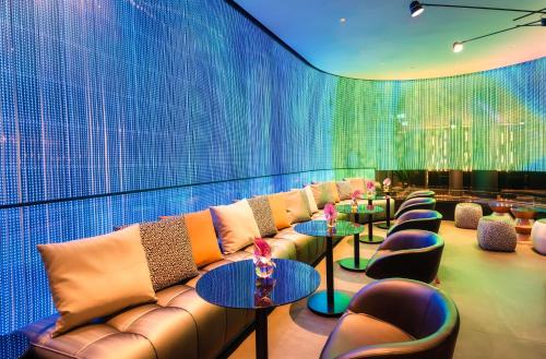 a room with a couch and tables and chairs at Park Plaza Budapest in Budapest