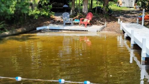 deux chaises assises sur un quai dans une masse d'eau dans l'établissement The Secret Place, à Paisley