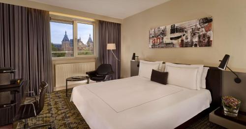 a hotel room with a large white bed and a window at Park Plaza Victoria Amsterdam in Amsterdam
