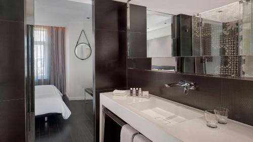 La salle de bains est pourvue d'un lavabo et d'un miroir. dans l'établissement Park Plaza Victoria Amsterdam, à Amsterdam