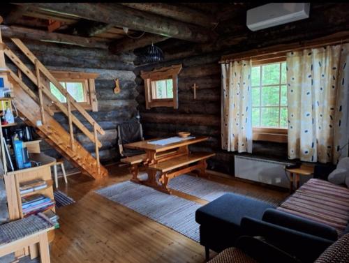 een woonkamer van een blokhut met een trap bij Kelola Cottage in Keyritty