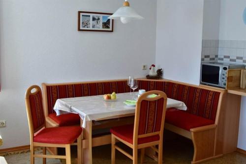 a kitchen with a table with chairs and a white table and a table at Ferienwohnung Habit in Schruns-Tschagguns