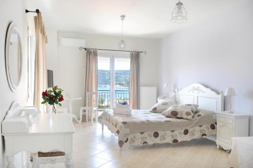 ein weißes Schlafzimmer mit einem Bett und einem Fenster in der Unterkunft Triantafilia Guesthouse in Agio Apóstoloi