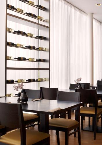 a dining room with a table and chairs and a shelf at Park Plaza Amsterdam Airport in Lijnden
