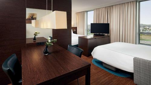 a hotel room with a bed and a desk with a bed and a desk at Park Plaza Amsterdam Airport in Lijnden