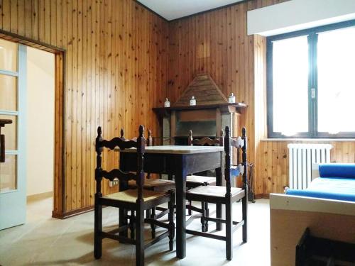 comedor con mesa, sillas y paredes de madera en Hoarder's Home en Fermo