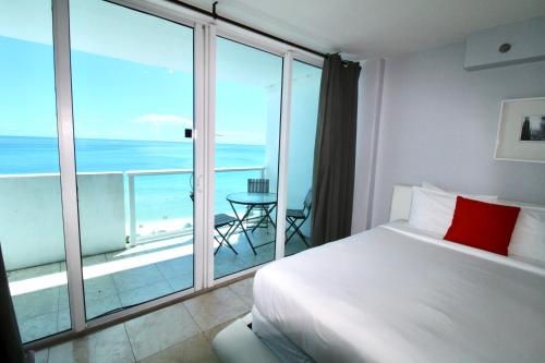 een slaapkamer met een bed en uitzicht op de oceaan bij Oceanfront views, balcony & gym, bars, beach access and free parking! in Miami Beach