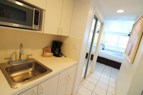 a kitchen with a sink and a microwave at Oceanview studio - on beach, gym, bars, and free parking! in Miami Beach