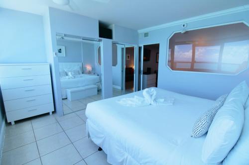 Habitación azul con cama y baño. en Oceanfront condo with ocean view beach, bar, free parking and gym! en Miami Beach