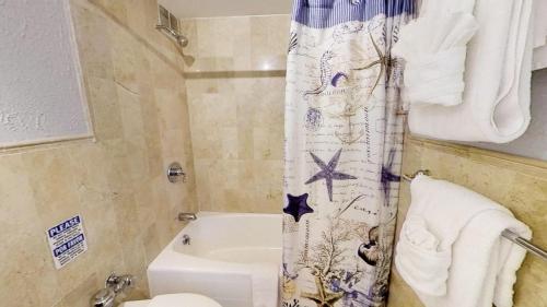 a bathroom with a toilet and a shower curtain at Oceanfront views, balcony & gym, bars, beach access and free parking! in Miami Beach
