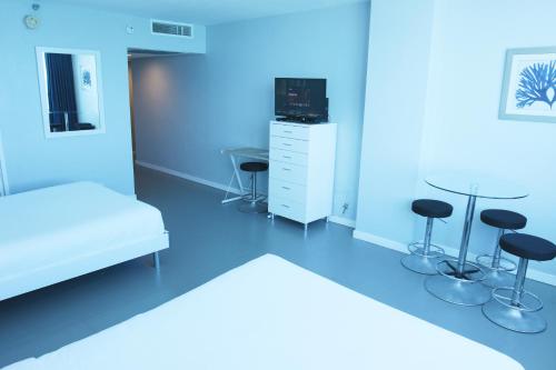 a hospital room with a bed and chairs and a table at Castle 835 Oceanview studio on beach with pool, gym, bars, and FREE Parking in Miami Beach