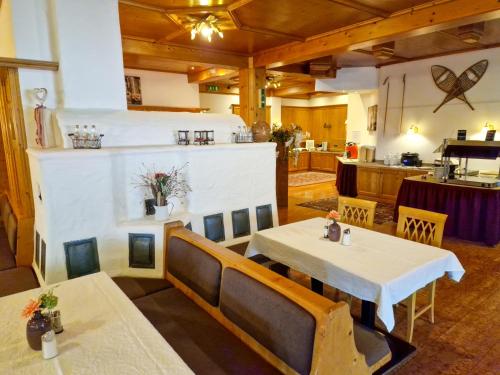 una sala da pranzo con 2 tavoli e una cucina di Das Alpin - Hotel Garni Guesthouse a Scheffau am Wilden Kaiser