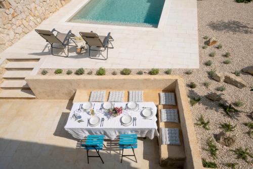 an overhead view of a table and chairs next to a pool at BRAND NEW Stone house MARCELA, 3 double bedrooms, pool in Lun