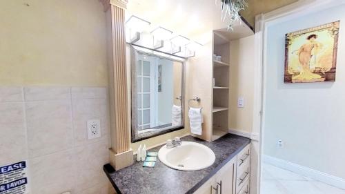 a bathroom with a sink and a mirror at Contemporary condo with gym, beach access and free parking in Miami Beach