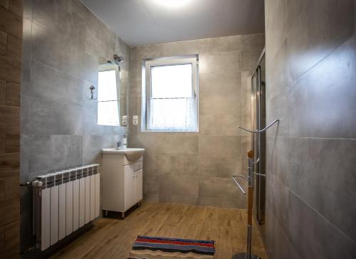 a bathroom with a sink and a radiator and a window at Noclegi- Bałuc Małgorzata in Czorsztyn