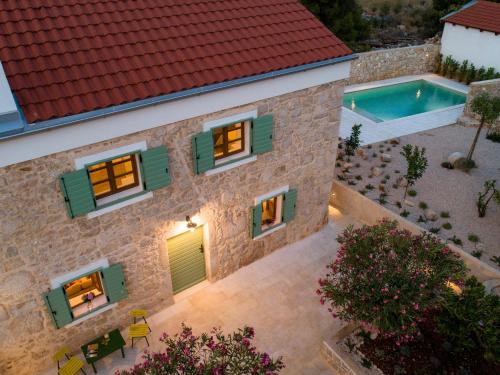 an aerial view of a house with a swimming pool at BRAND NEW Stone house MARCELA, 3 double bedrooms, pool in Lun